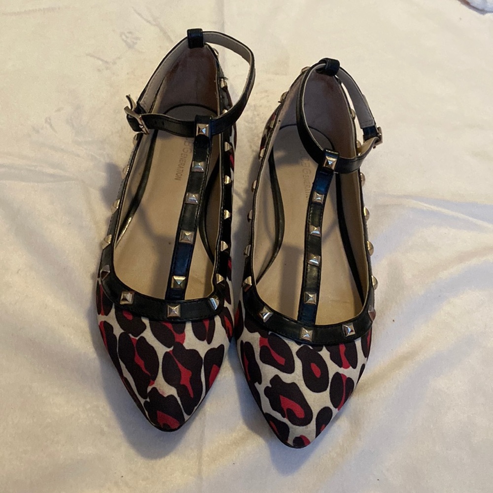 Pink and black leopard print ankle strap flats with silver stud embellishments.